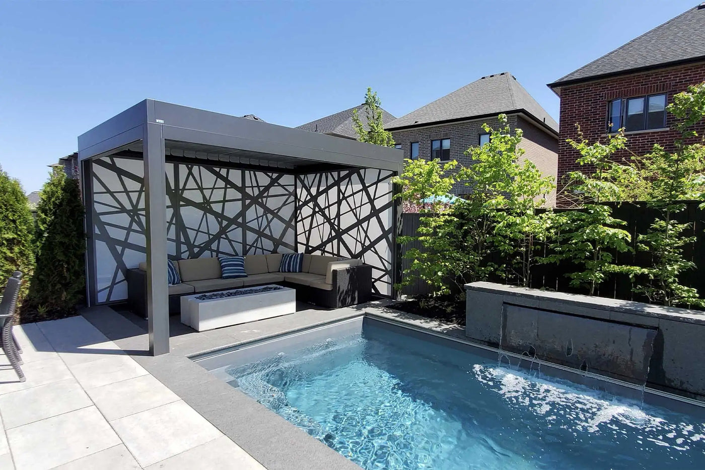 Modern black and white geometric pergola with cushioned seating.