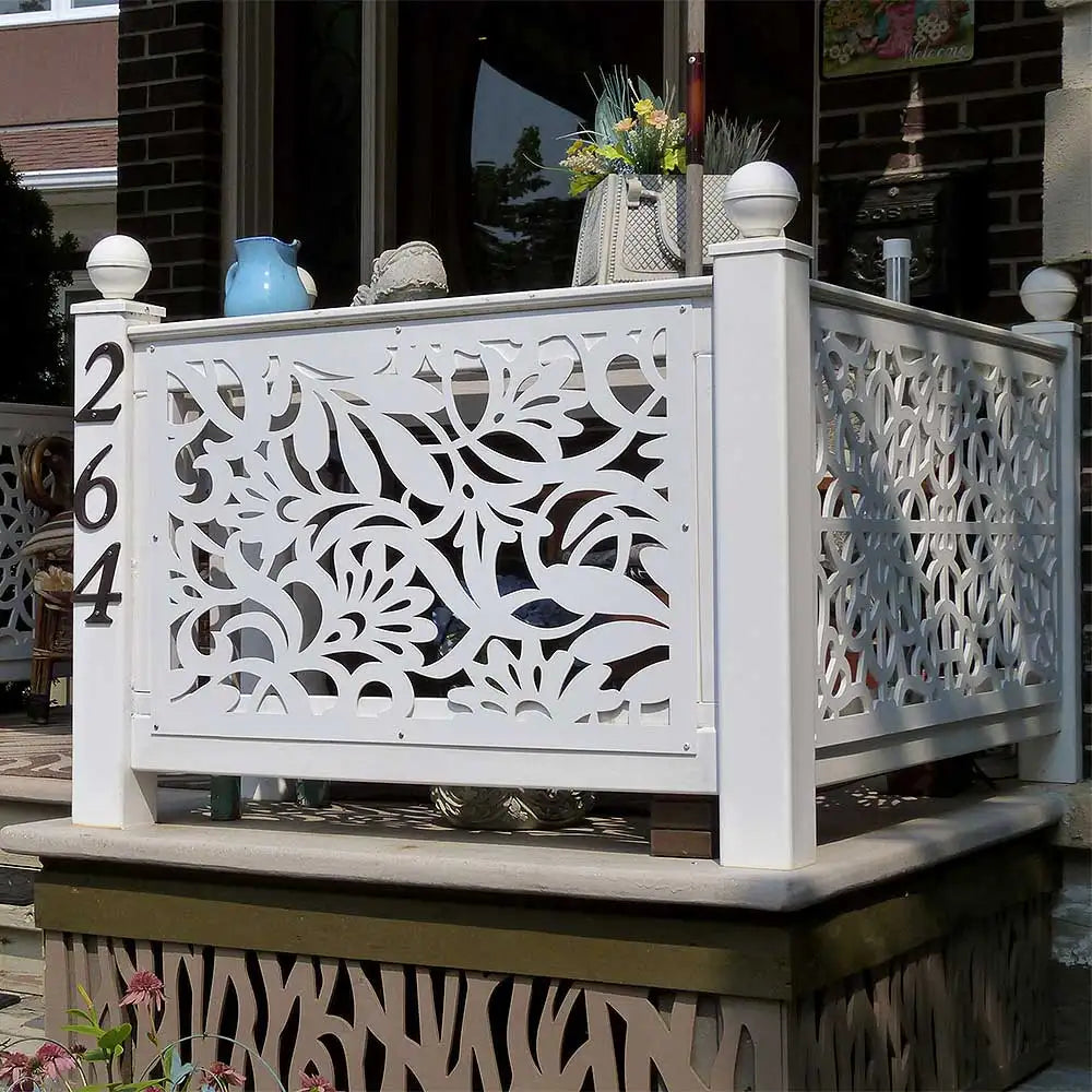 White decorative railing with intricate floral pattern and ball finials.