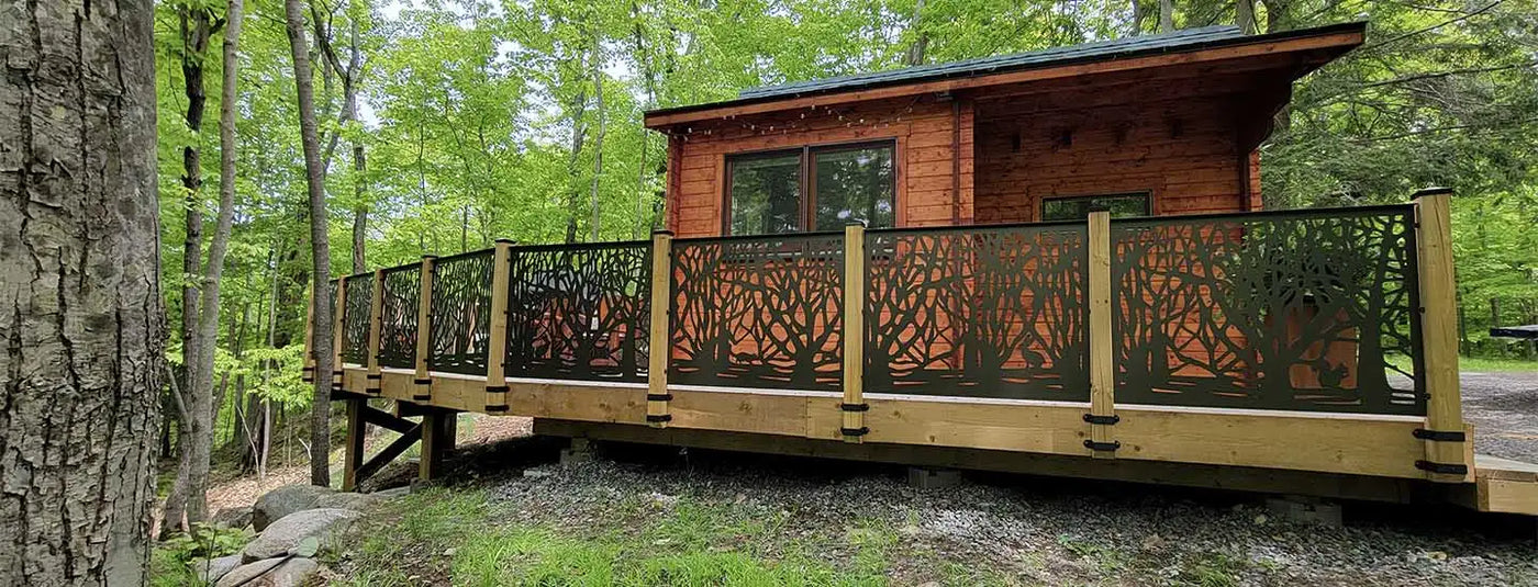 Wooden cabin with metal railing and tree branch design.