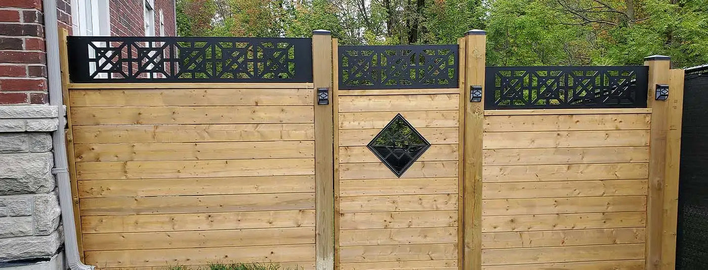 Wooden privacy fence with black metal accents and decorative diamond cutouts.