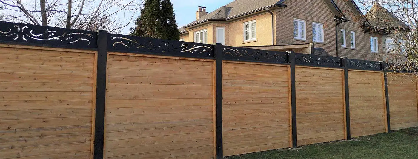 Wooden privacy fence with black metal accents and decorative patterns.